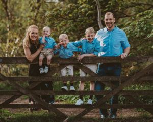 Family photograph by a gate in the woods