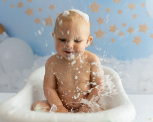 Baby boy splashing in a bubble bath