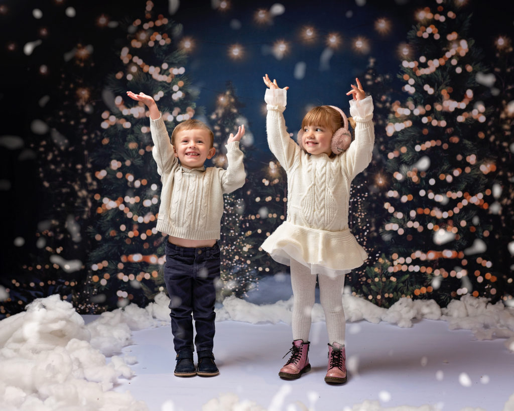 Two children play in the snow, wirral christmas portrait